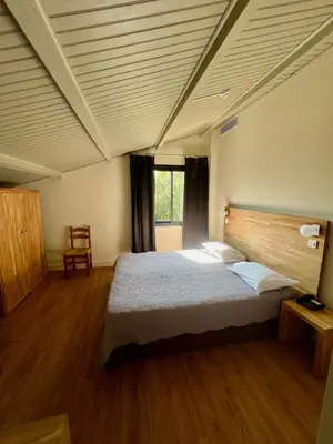 a bedroom with a large bed in a room at Logis Hotel Le Lonca in Porto Ota