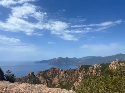 a view of the ocean from a mountain at Logis Hotel Le Lonca in Porto Ota