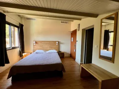 a bedroom with a bed and a mirror at Logis Hotel Le Lonca in Porto Ota