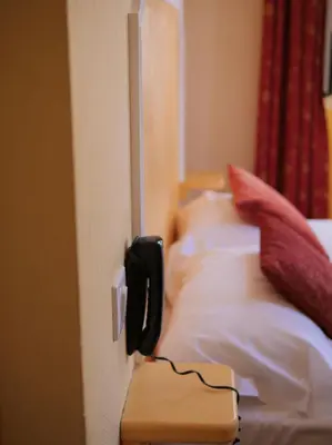 a bedroom with a bed and a window and a television at Hôtel U Palazzu & Spa in Venaco