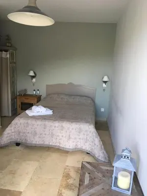 a bedroom with a bed and a table with a lamp at Ferme de Roccapina in Sarragia