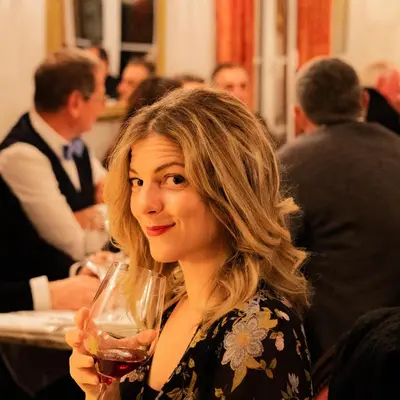 a woman is holding a glass of wine at Hôtel Restaurant U Castellu Vizzavona in Vizzavona