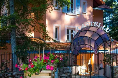 a building with a gate and flowers in front of it at Hôtel Restaurant U Castellu Vizzavona in Vizzavona
