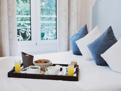 a tray of breakfast food on a bed with pillows at Hôtel Restaurant U Castellu Vizzavona in Vizzavona