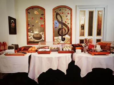 two tables with food on them in a room with windows at Hôtel Restaurant U Castellu Vizzavona in Vizzavona