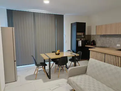 a living room and kitchen with a table and chairs at Les Sables Blancs de la Liscia in Calcatoggio