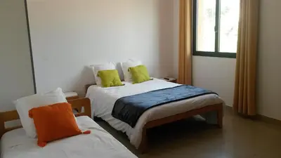 a bedroom with two twin beds and a window at Les Sables Blancs de la Liscia in Calcatoggio