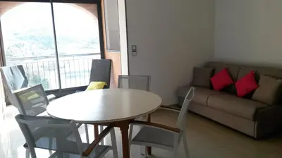 a living room with a table and a couch at Les Sables Blancs de la Liscia in Calcatoggio