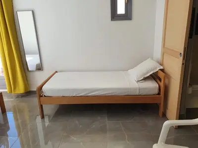 a small bed in a room with a mirror at Les Sables Blancs de la Liscia in Calcatoggio