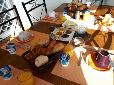 a table with a breakfast of bread and orange juice at Villa Emmony in Santo-Pietro-di-Venaco
