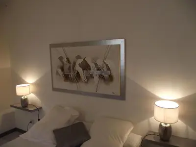 a bedroom with a bed with two lamps and a picture on the wall at Villa Emmony in Santo-Pietro-di-Venaco