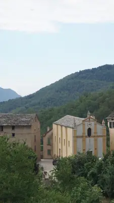 a group of buildings in front of a mountain at L'appollu in La Porta