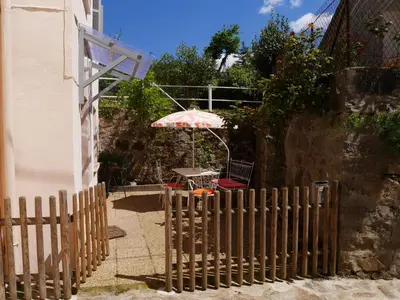 a wooden fence with a table and an umbrella at A Cittadella in Vico