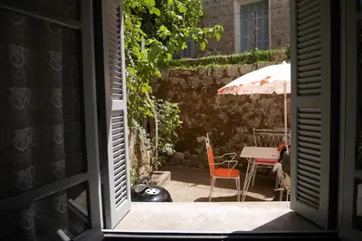 an open door to a patio with a table and an umbrella at A Cittadella in Vico