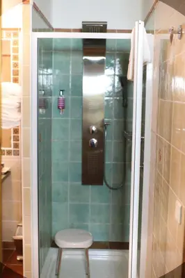 a glass shower with a stool in a bathroom at Casa Di Lucia Mi-Hotel in Mazzola