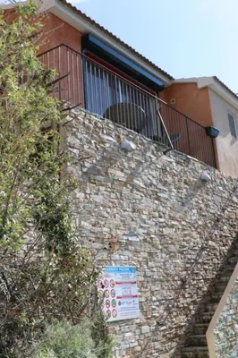 a brick wall with a balcony on top of it at Casa Di Lucia Mi-Hotel in Mazzola