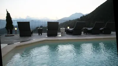 a swimming pool with chairs and a table in front of it at Casa Di Lucia Mi-Hotel in Mazzola
