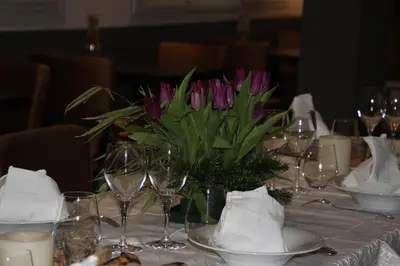 a table with a vase of purple flowers on it at Casa Di Lucia Mi-Hotel in Mazzola