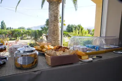a table topped with a tray of bread and cheese at Hotel Cesario in Calvi