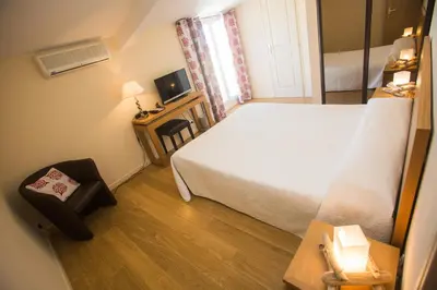 a small room with a bed and a television at Hotel Cesario in Calvi