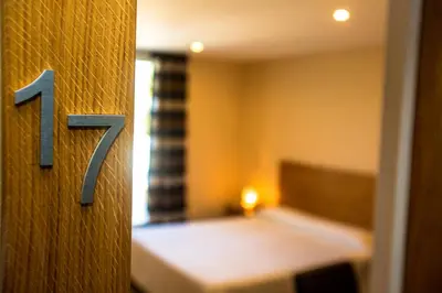 a room with a number on a door with a bed at Hotel Cesario in Calvi
