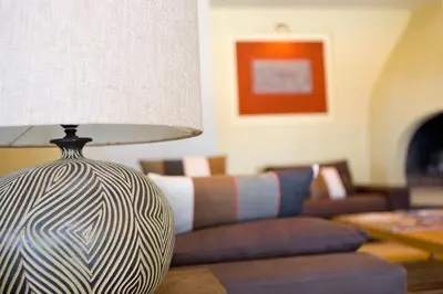 a lamp sitting on a table next to a couch at Hotel Cesario in Calvi