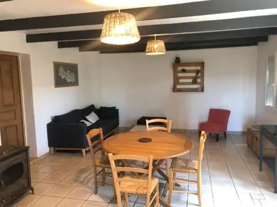 a living room with a table and chairs and a couch at Maison de Campagne in Sarragia