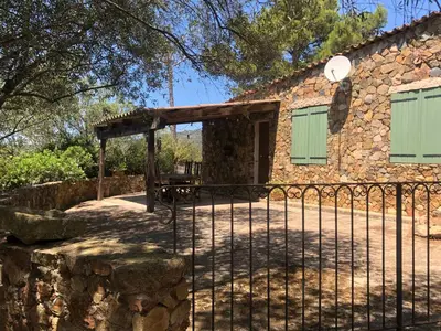 a stone house with a gate and a fence at Maison de Campagne in Sarragia