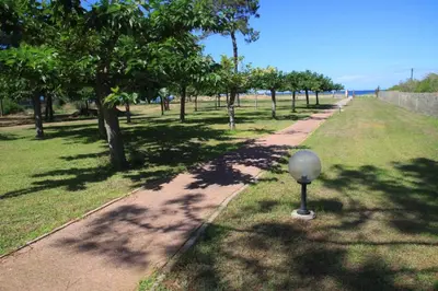 a path in a park with a ball in the grass at Isola Hôtel in Borgo