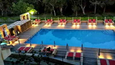 a swimming pool with a deck and chairs next to it at Isola Hôtel in Borgo