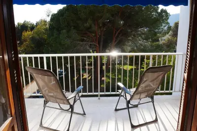 two chairs sitting on the porch of a house at A U Mare in Sagone