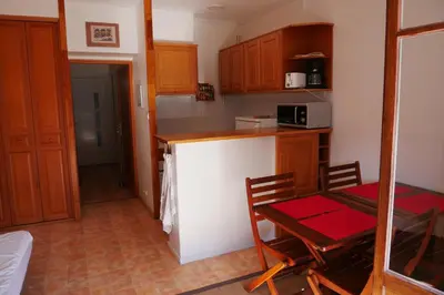 a small kitchen with a table and a microwave at A U Mare in Sagone