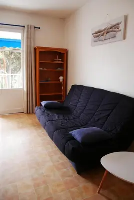 a bed in a room with a table and a window at A U Mare in Sagone
