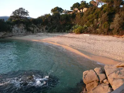a beach with a rocky shore and the ocean at A U Mare in Sagone