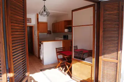 a kitchen with a table and a chair in a room at A U Mare in Sagone