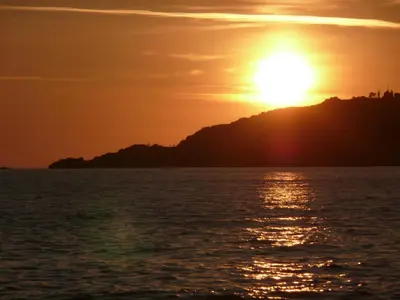 an image of the sun setting over the ocean at A U Mare in Sagone