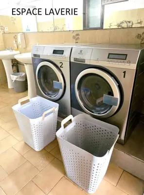 a washer and dryer sitting in a laundry room at Hotel Olmuccio in Sainte-Lucie de Porto-Vecchio