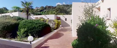 a brick walkway next to a white building at Hotel Olmuccio in Sainte-Lucie de Porto-Vecchio