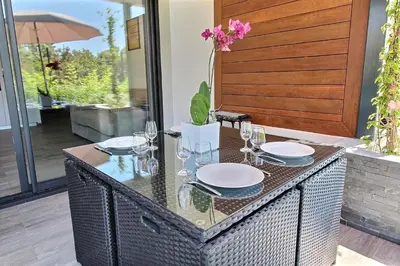 a glass table with plates and glasses on it at Residence ACQUA LINDA Porticcio in Porticcio