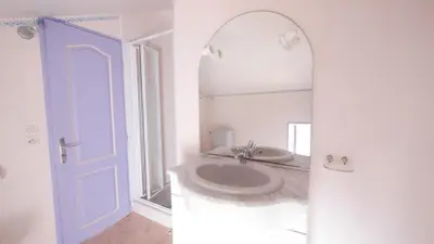 a white bathroom with a sink and a mirror at Les Figuiers in Porto Pollo
