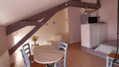 a room with a table and chairs and a bed at Les Figuiers in Porto Pollo