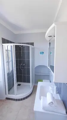 a large bathroom with a shower and a sink at Les Figuiers in Porto Pollo