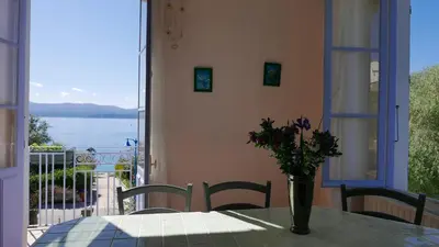 a table with a vase of flowers on a balcony at Les Figuiers in Porto Pollo