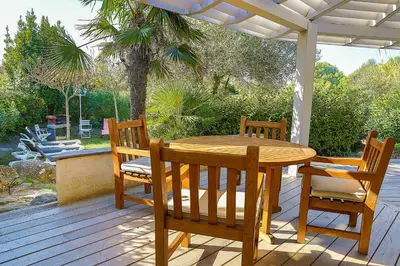 a wooden table and chairs on a wooden deck at Villa Cartarana in Bonifacio