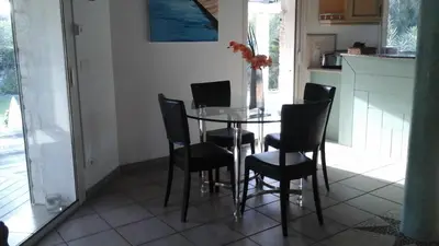 a dining room with a glass table and black chairs at Villa Cartarana in Bonifacio