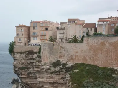a group of buildings on a cliff next to the water at Villa Cartarana in Bonifacio