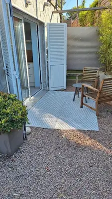 a patio with a bench and an open door at T2 de 45 m2 sur Porticcio avec Jardin in Porticcio