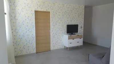 a room with a television on a dresser and a door at T2 de 45 m2 sur Porticcio avec Jardin in Porticcio