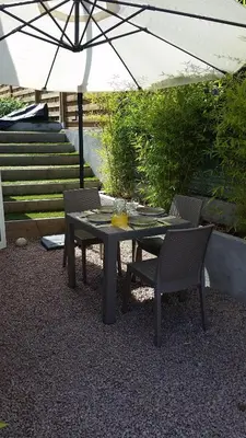 a table with two chairs and an umbrella at T2 de 45 m2 sur Porticcio avec Jardin in Porticcio