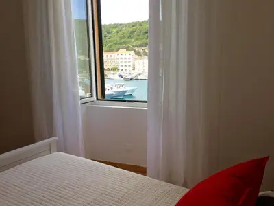 a bedroom with a window with a view of the water at Les Appartements du Port in Bonifacio